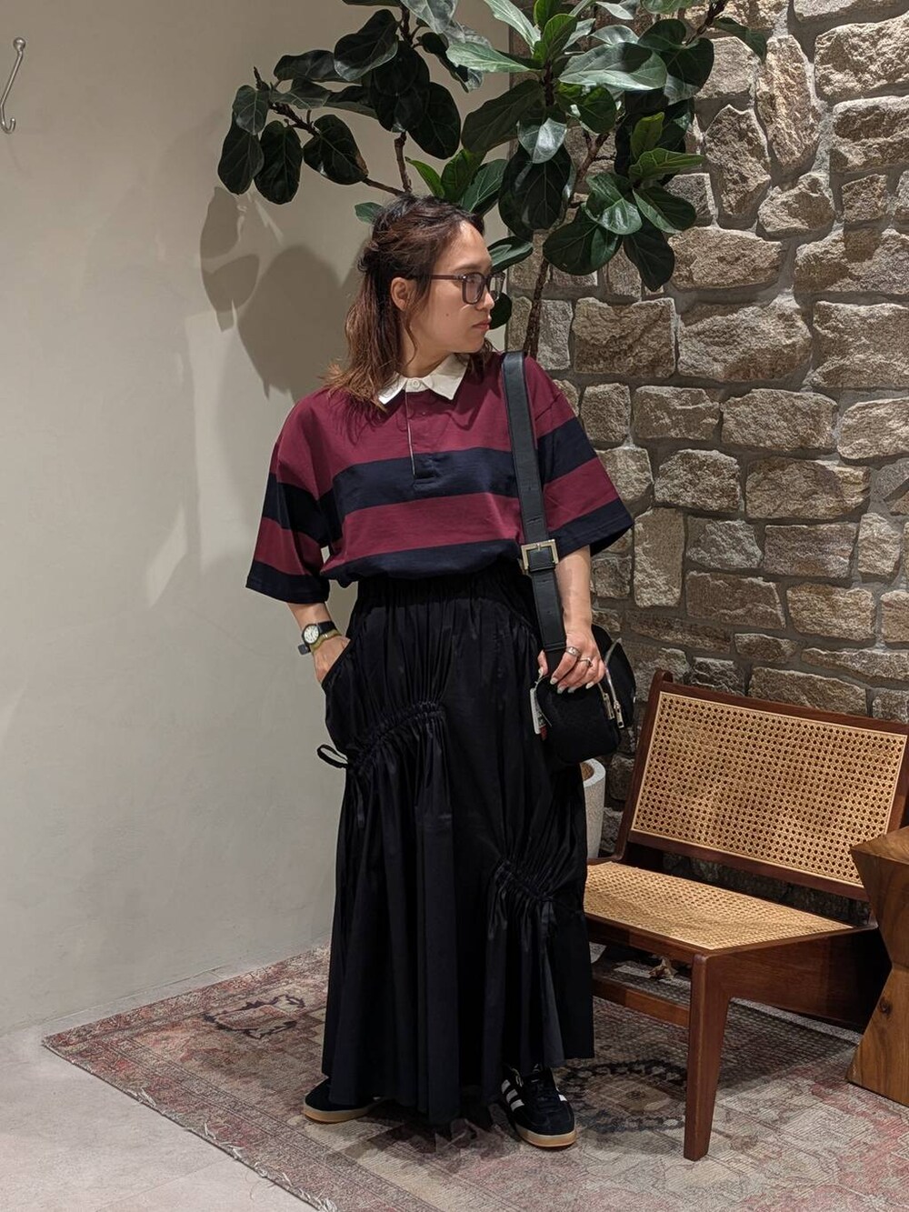 ブラック系のスニーカー、ブラック系のショルダーバッグ、ブルー系のその他トップスを着用したレディースの夏コーディネートの2枚目の写真