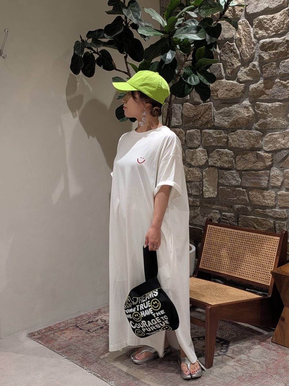 シルバー系のサンダル、ホワイト系のワンピース、グリーン系のキャップを着用したレディースの夏コーディネートの3枚目の写真