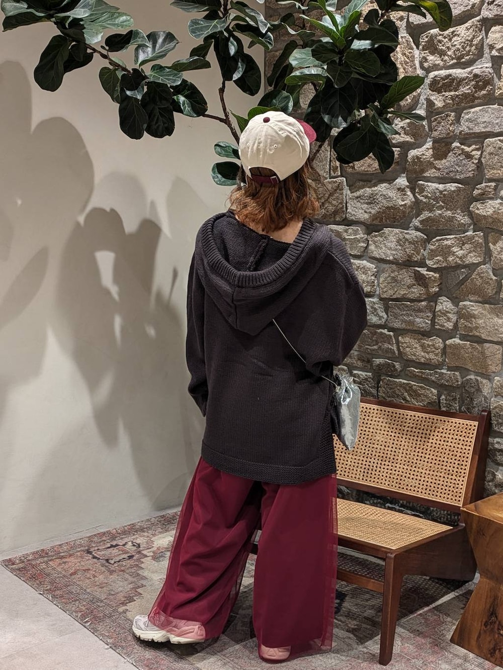 グレー系のスニーカー、シルバー系のショルダーバッグ、グレー系のニット/セーターを着用したレディースの秋コーディネートの2枚目の写真