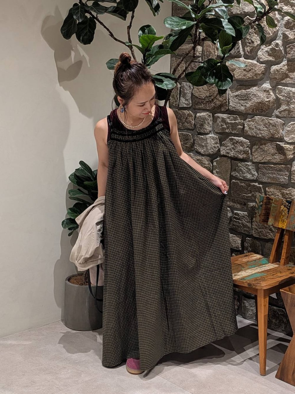 イエロー系のワンピース、ブラウン系のタンクトップ、ベージュ系のブルゾンを着用したレディースの夏コーディネートの3枚目の写真