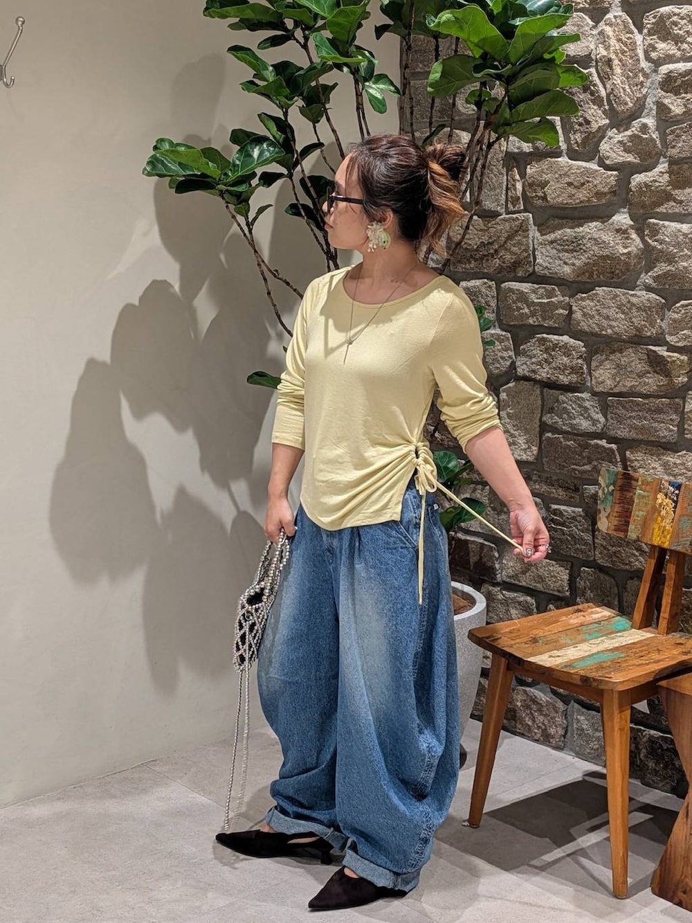 シルバー系のショルダーバッグ、ブラウン系のパンプス、イエロー系のTシャツ/カットソーを着用したレディースの秋コーディネートの2枚目の写真