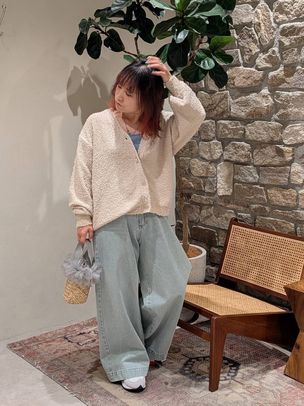 グレー系のスニーカー、ブルー系のキャミソール、グリーン系のデニムパンツを着用したレディースの春コーディネートの2枚目の写真