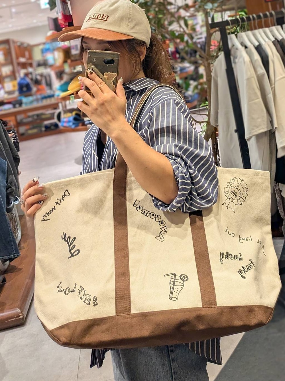 ブラウン系のトートバッグ、ブルー系のトートバッグ、ブルー系のシャツ/ブラウスを着用したレディースの秋コーディネートの2枚目の写真