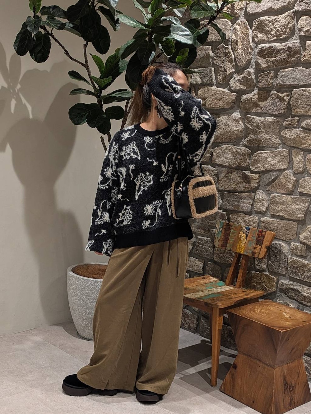 ブラック系のハンドバッグ、グリーン系のその他パンツ、ブラック系のニット/セーターを着用したレディースの秋コーディネートの2枚目の写真