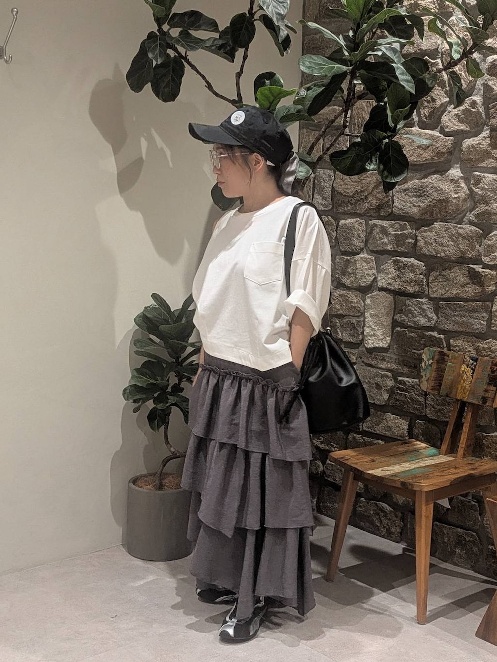 グレー系のワンピース、ブラック系のショルダーバッグ、ブラック系のスニーカーを着用したレディースの夏コーディネートの2枚目の写真