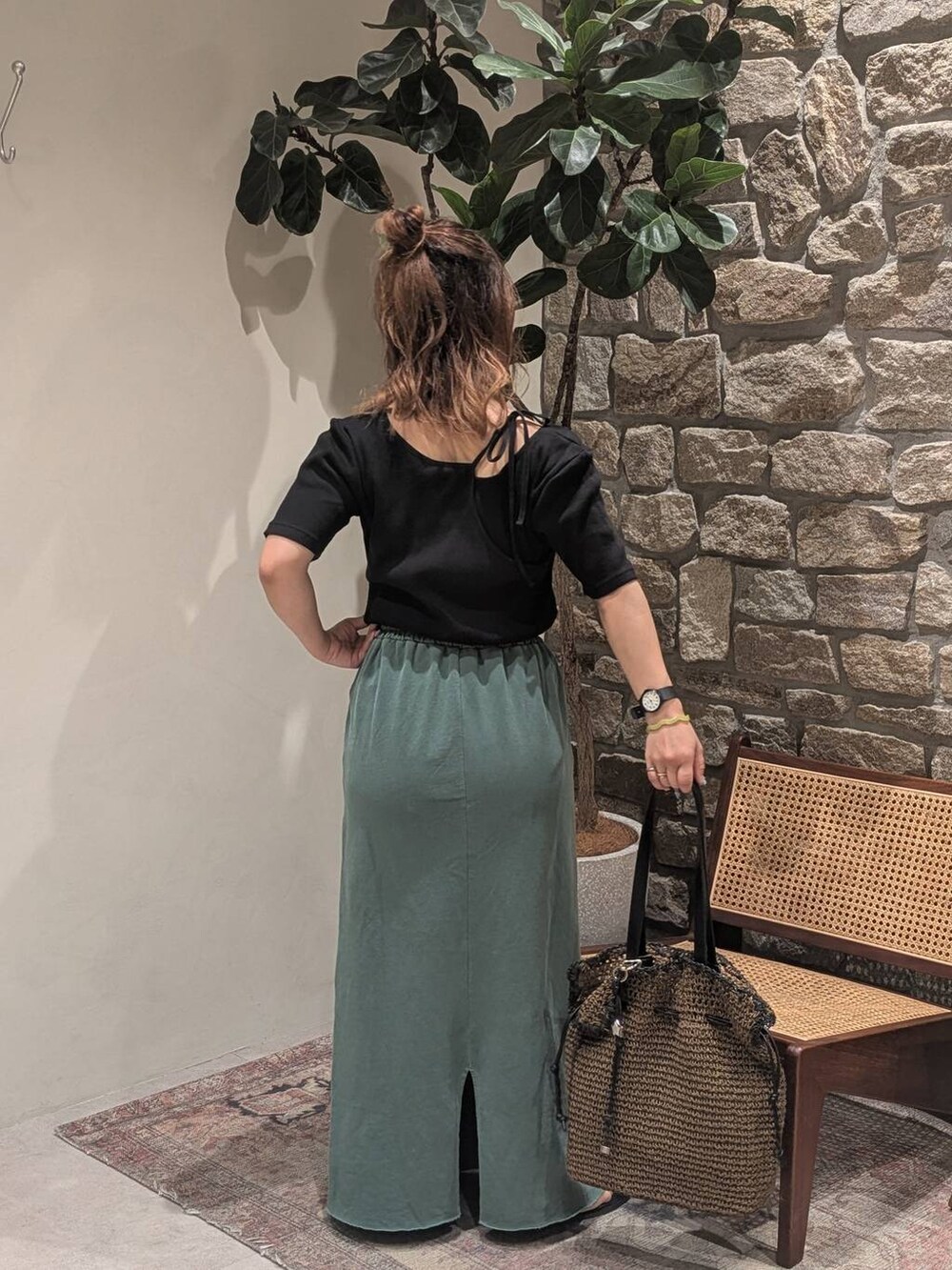 ブラウン系のトートバッグ、ブラック系のサンダル、グリーン系のスカートを着用したレディースの春コーディネートの2枚目の写真