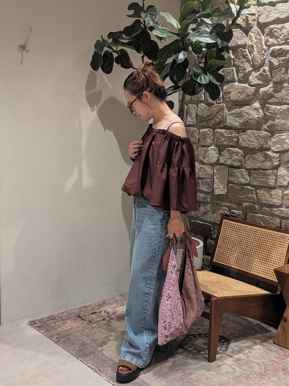 ブルー系のデニムパンツ、ブラウン系のシャツ/ブラウス、ブラウン系のサンダルを着用したレディースの夏コーディネートの2枚目の写真