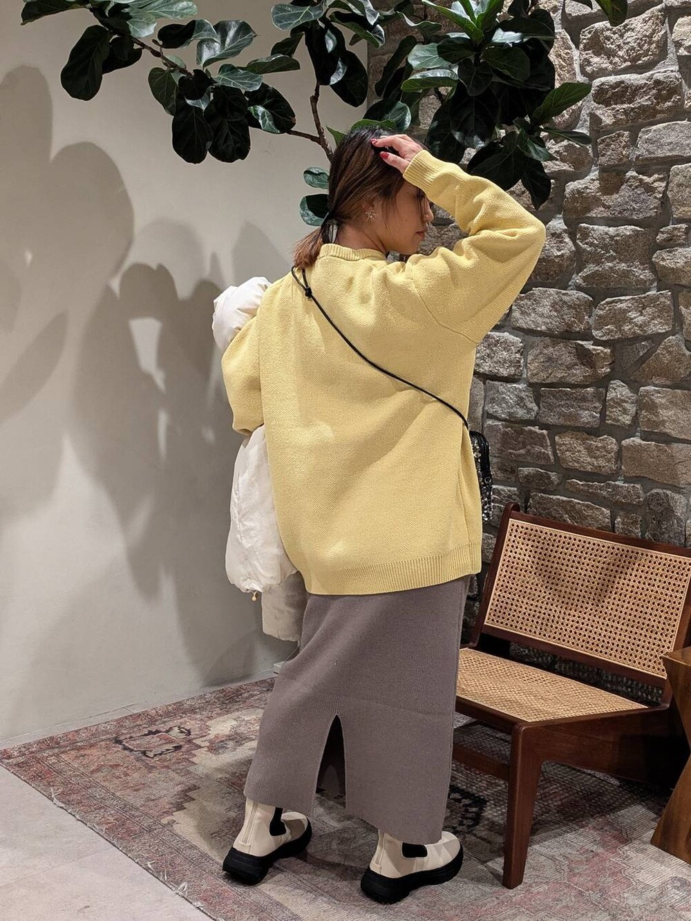 グレー系のショルダーバッグ、ホワイト系のダウンジャケット/コート、ブラウン系のスカートを着用したレディースの秋コーディネートの4枚目の写真