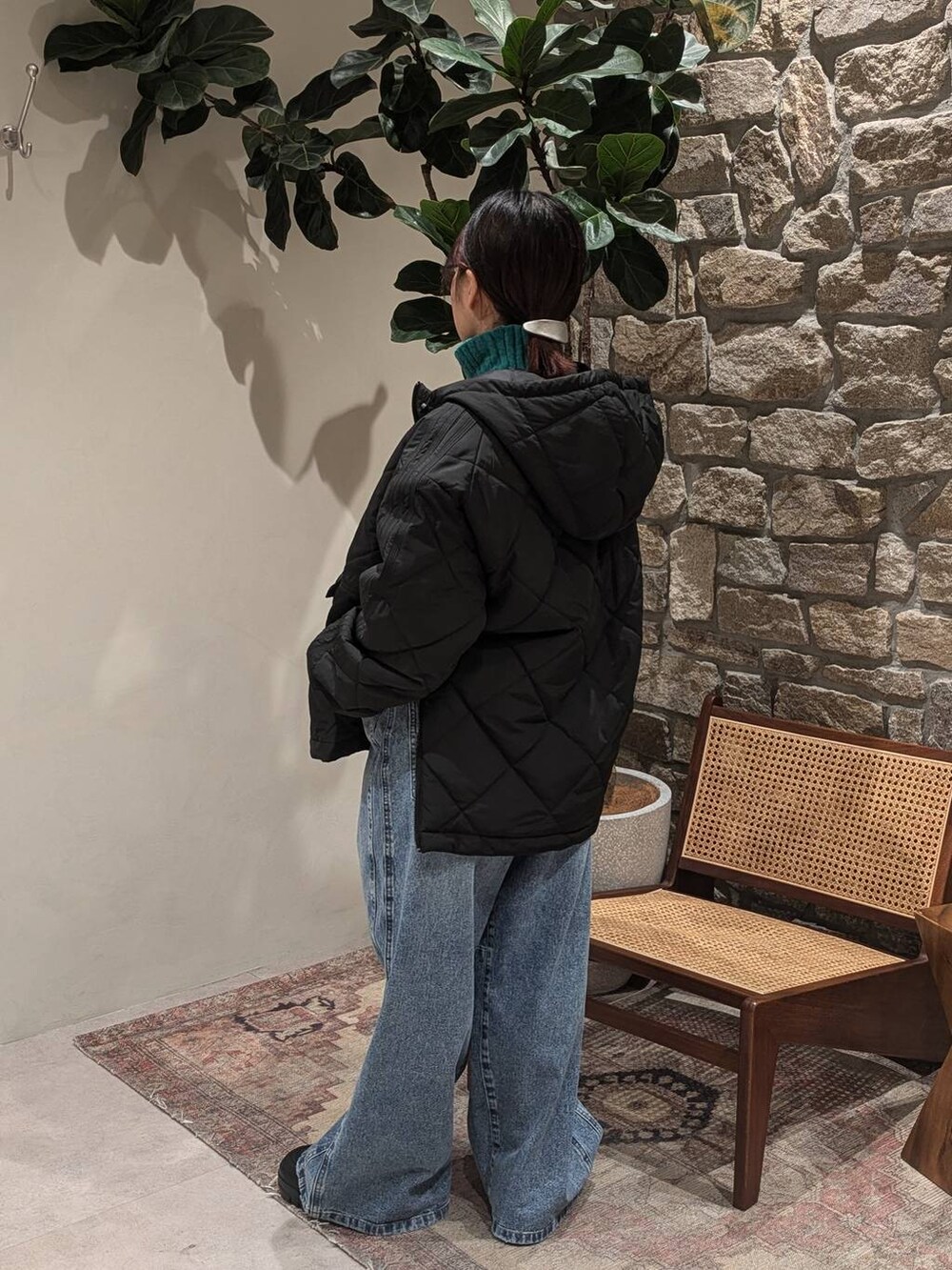 ブラック系のスニーカー、グリーン系のニット/セーター、ブラック系のその他アウターを着用したレディースの冬コーディネートの2枚目の写真