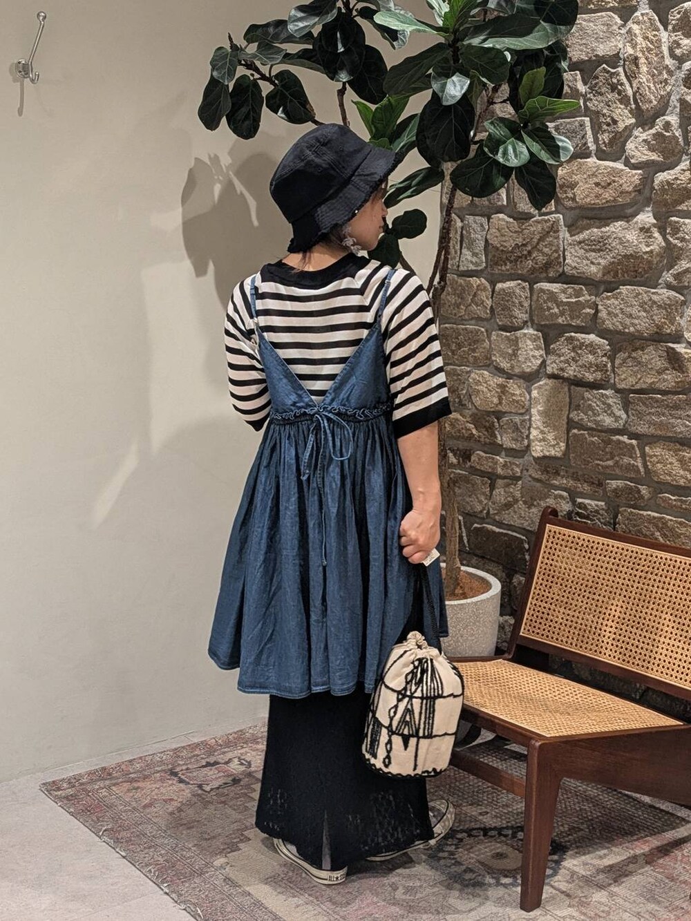 グレー系のスニーカー、ブラック系のスカート、ブラック系のハンドバッグを着用したレディースの春コーディネートの2枚目の写真