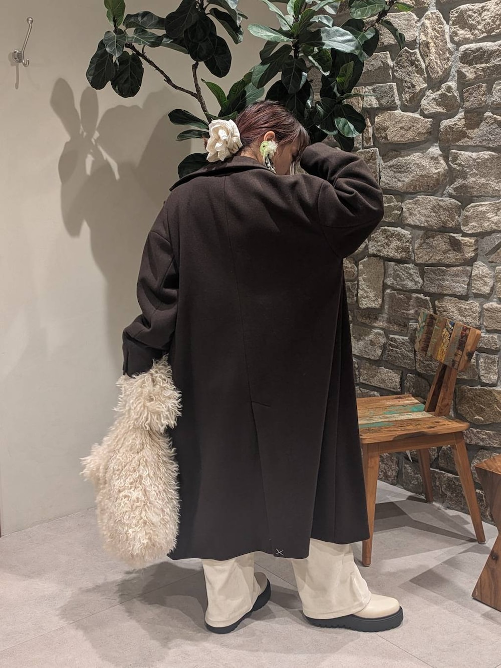 ブラウン系のチェスターコート、ベージュ系のブーツ、ベージュ系のショルダーバッグを着用したレディースの冬コーディネートの4枚目の写真