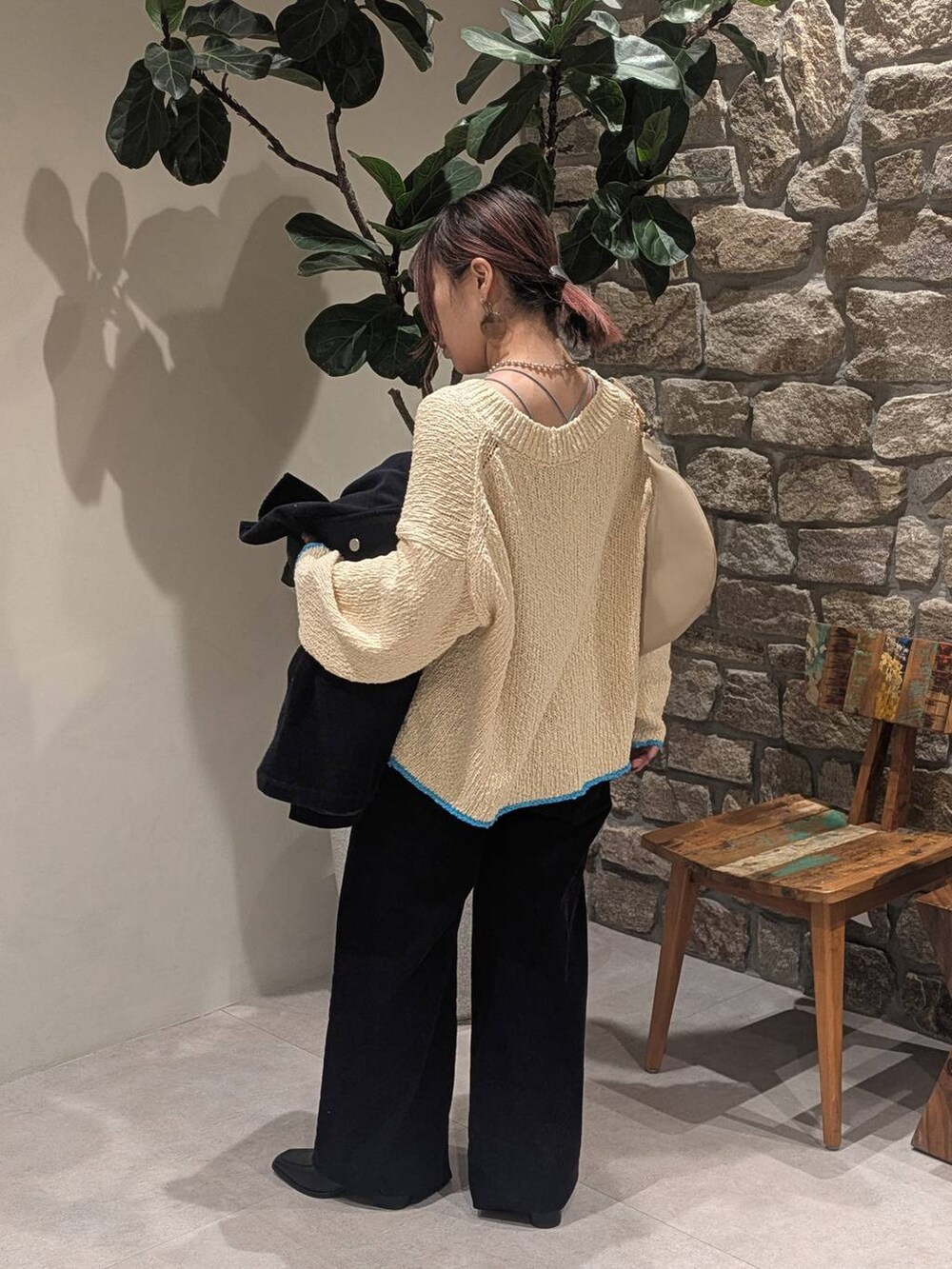 ベージュ系のハンドバッグ、ブラック系のブーツ、ホワイト系のニット/セーターを着用したレディースの冬コーディネートの4枚目の写真