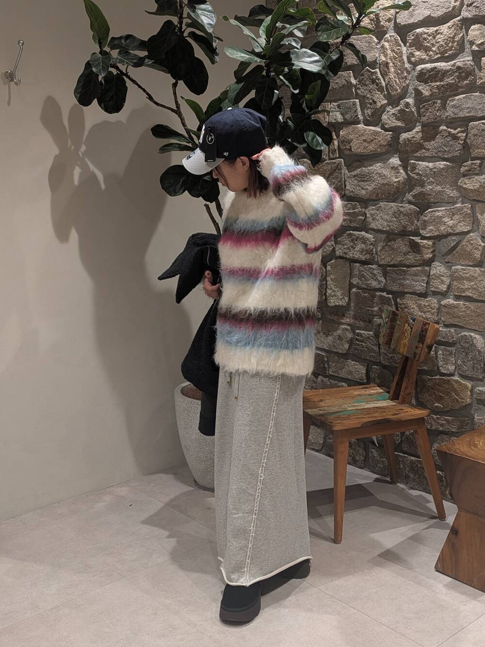 グレー系のその他アウター、シルバー系のハンドバッグ、ホワイト系のニット/セーターを着用したレディースの冬コーディネートの3枚目の写真