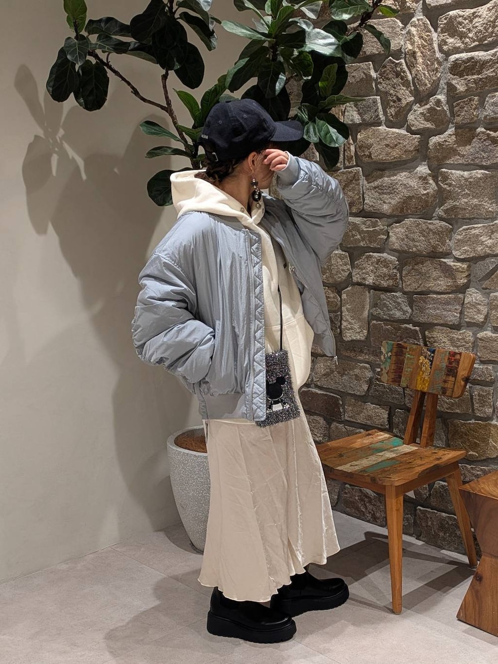 ブラック系のブーツ、ブラック系のショルダーバッグ、ホワイト系のパーカーを着用したレディースの秋コーディネートの2枚目の写真