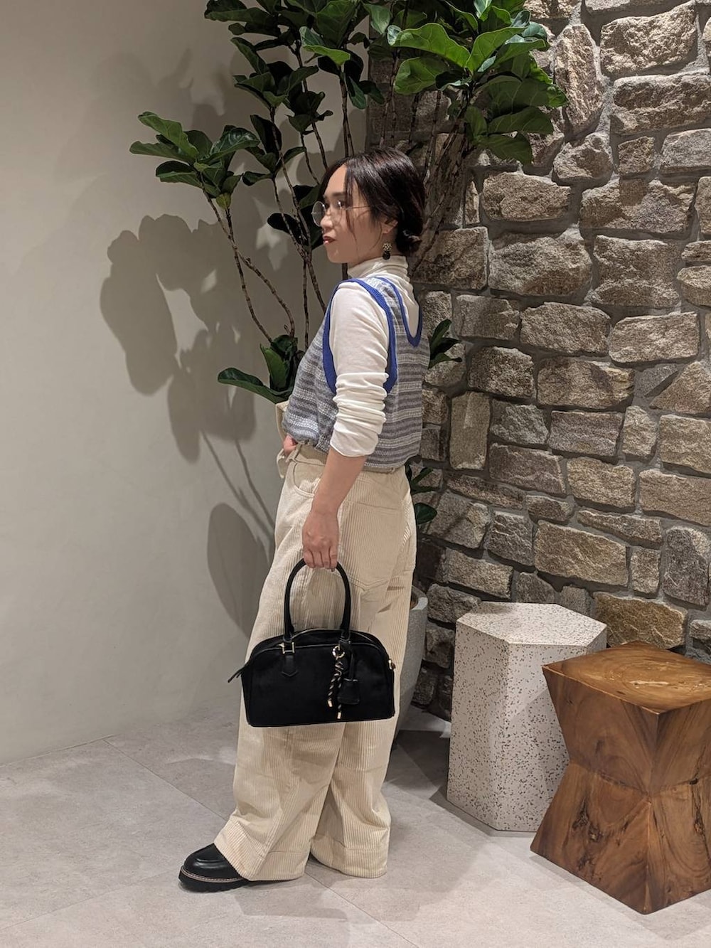 ホワイト系のブルゾン、ホワイト系のその他パンツ、ブラック系のハンドバッグを着用したレディースの秋コーディネートの2枚目の写真