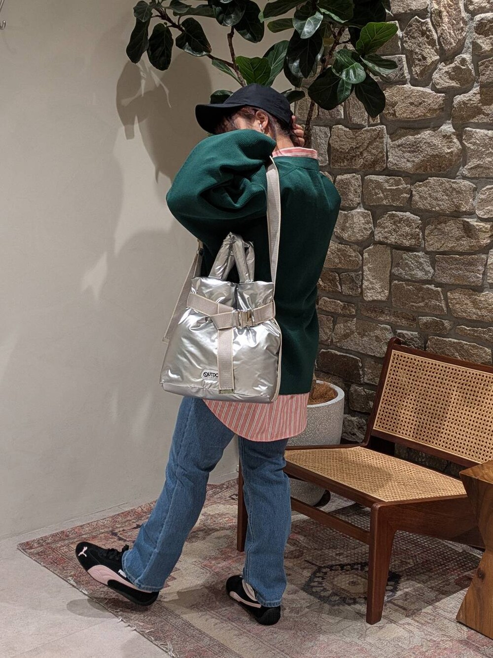 グリーン系のカーディガン/ボレロ、シルバー系のトートバッグ、ブルー系のデニムパンツを着用したレディースの冬コーディネートの2枚目の写真