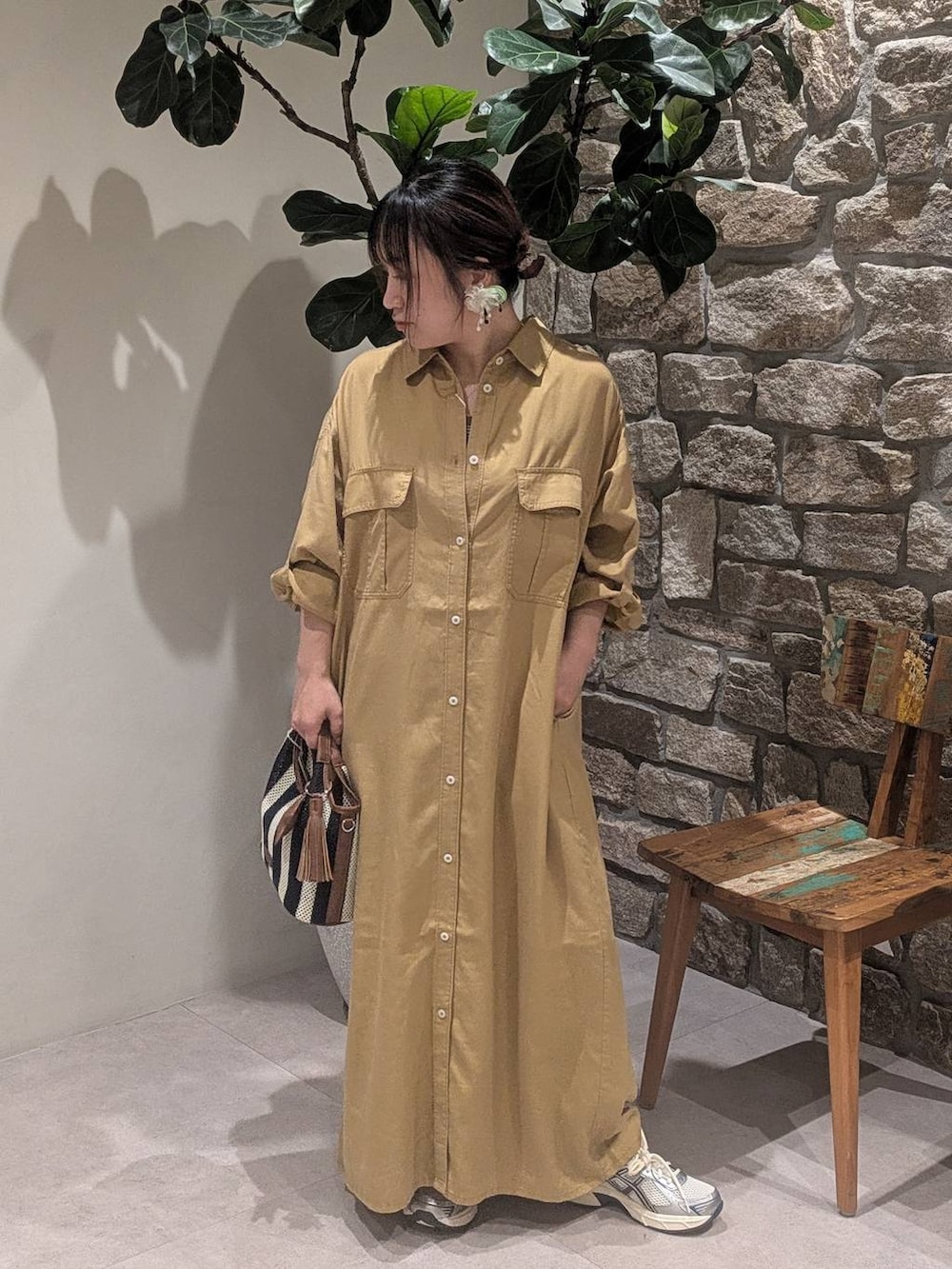 ベージュ系のスニーカー、ブルー系のショルダーバッグ、イエロー系のワンピースを着用したレディースの春コーディネートの2枚目の写真