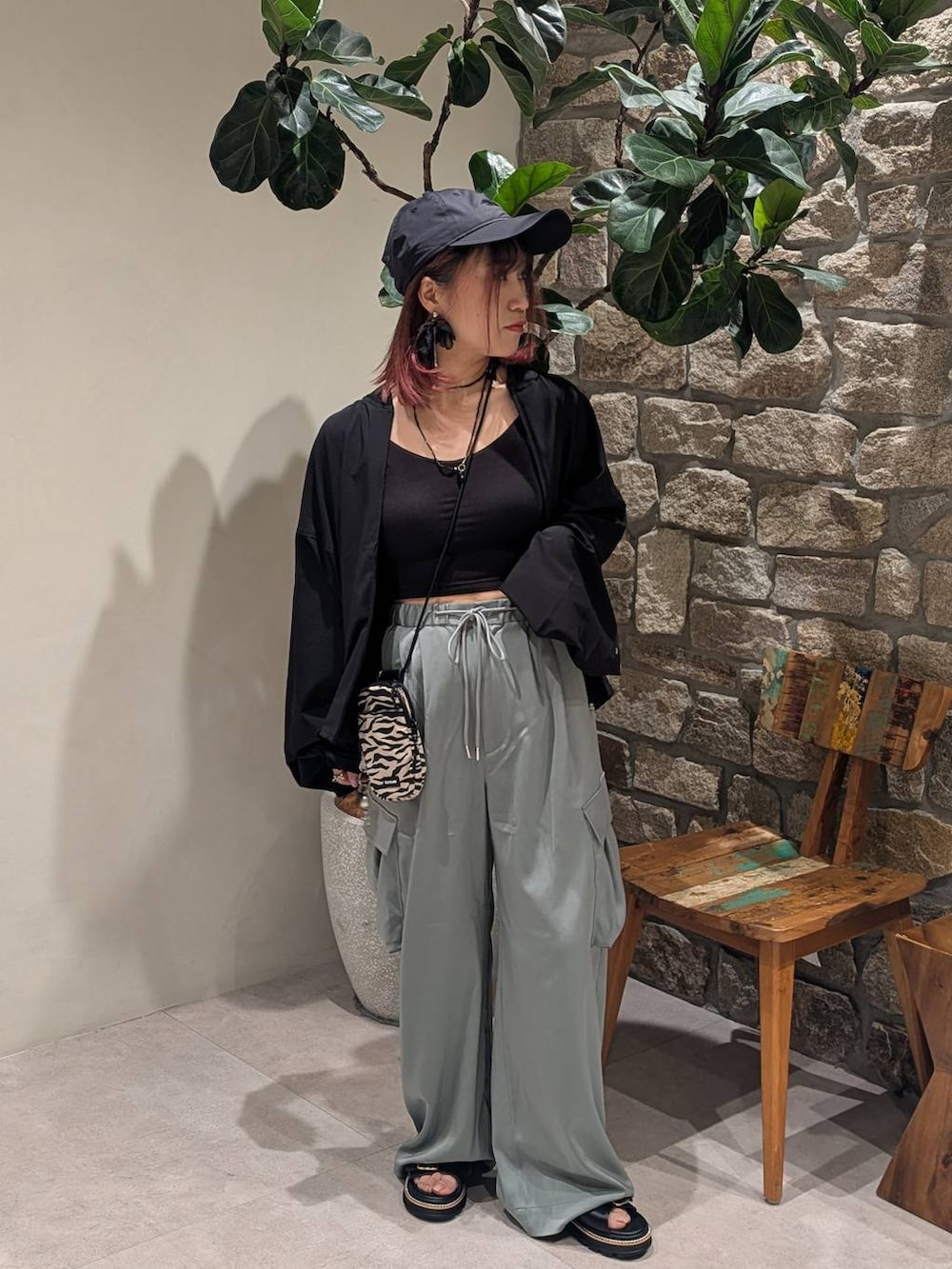 ベージュ系のショルダーバッグ、ブラック系のサンダル、ブラック系のブルゾンを着用したレディースの春コーディネートの2枚目の写真