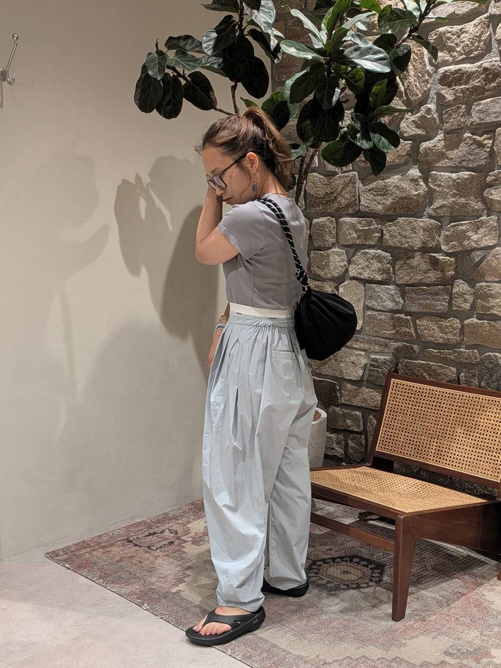 ブラック系のショルダーバッグ、グレー系のTシャツ/カットソー、ブラック系のサンダルを着用したレディースの夏コーディネートの3枚目の写真