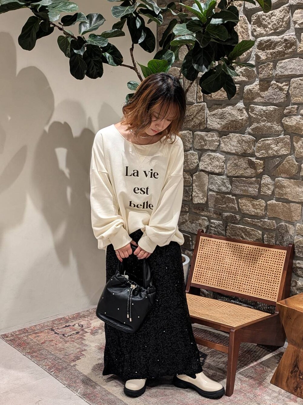 ホワイト系のブーツ、ブラウン系のその他アウター、ブラック系のスカートを着用したレディースの秋コーディネートの5枚目の写真