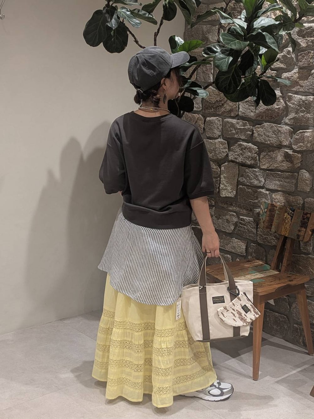 グレー系のスニーカー、ブラック系のTシャツ/カットソー、ベージュ系のトートバッグを着用したレディースの春コーディネートの3枚目の写真