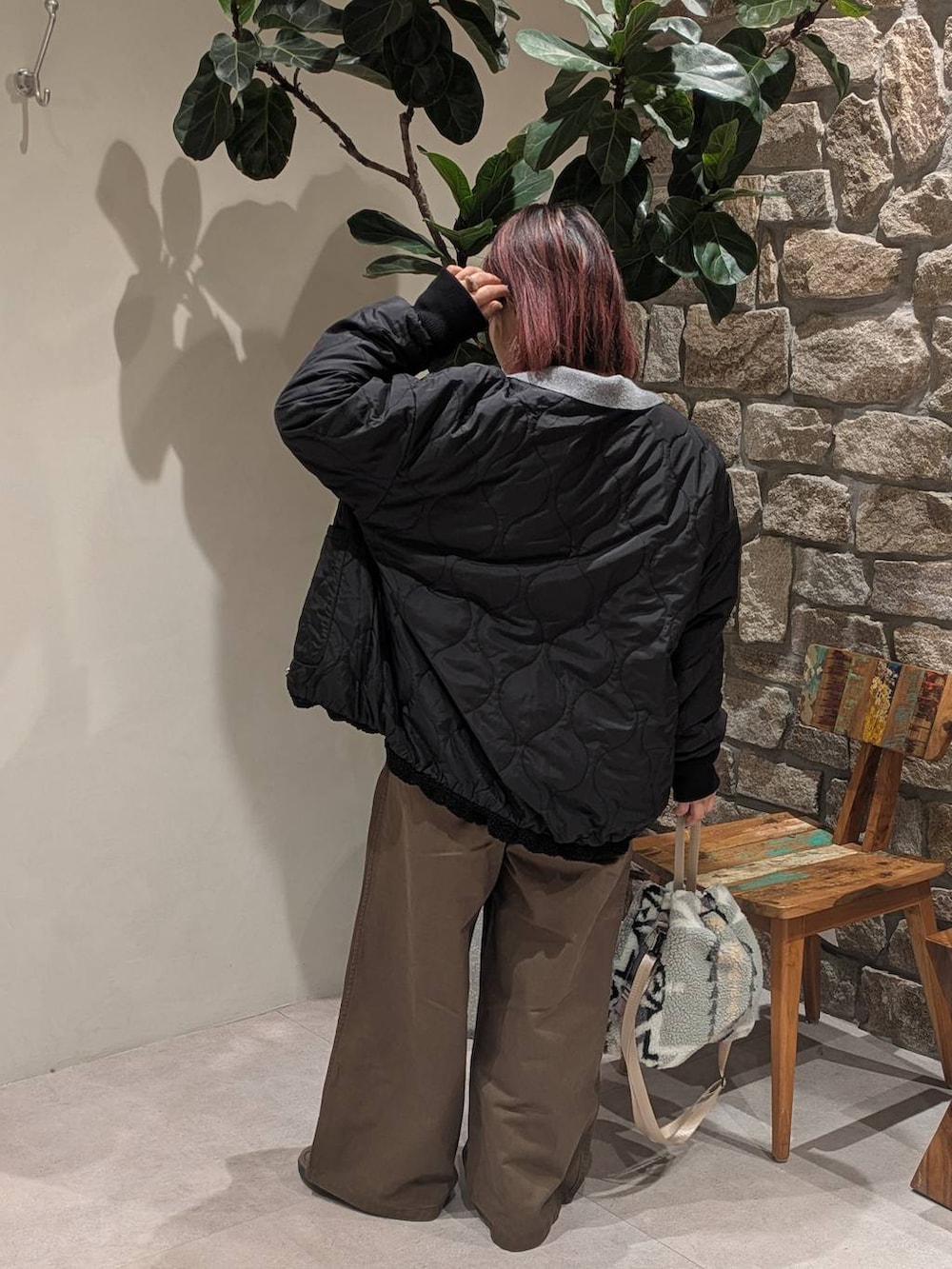 ブラウン系のスニーカー、グレー系のハンドバッグ、ブラック系のブルゾンを着用したレディースの冬コーディネートの5枚目の写真