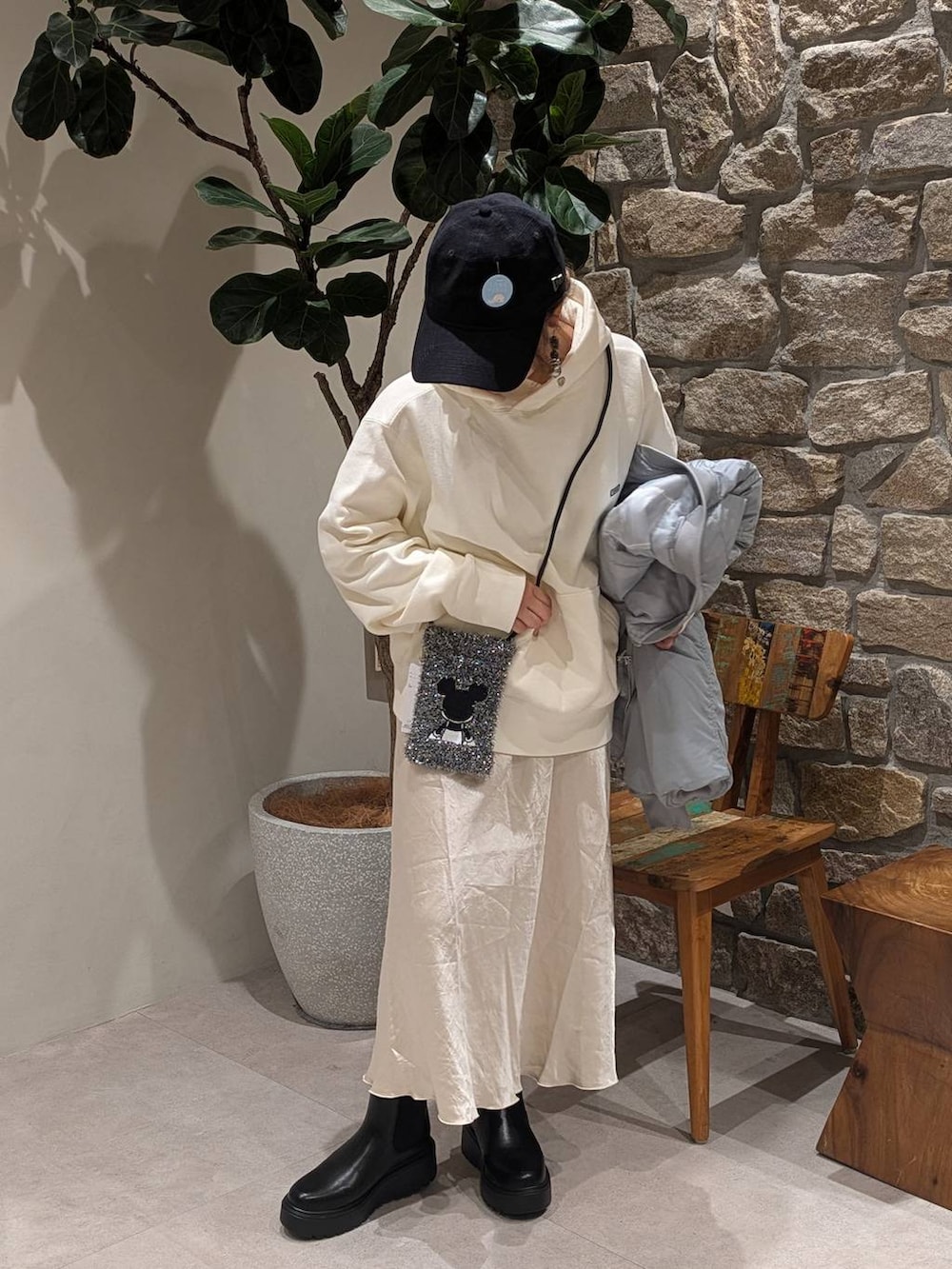 ブラック系のブーツ、ブラック系のショルダーバッグ、ホワイト系のパーカーを着用したレディースの秋コーディネートの4枚目の写真