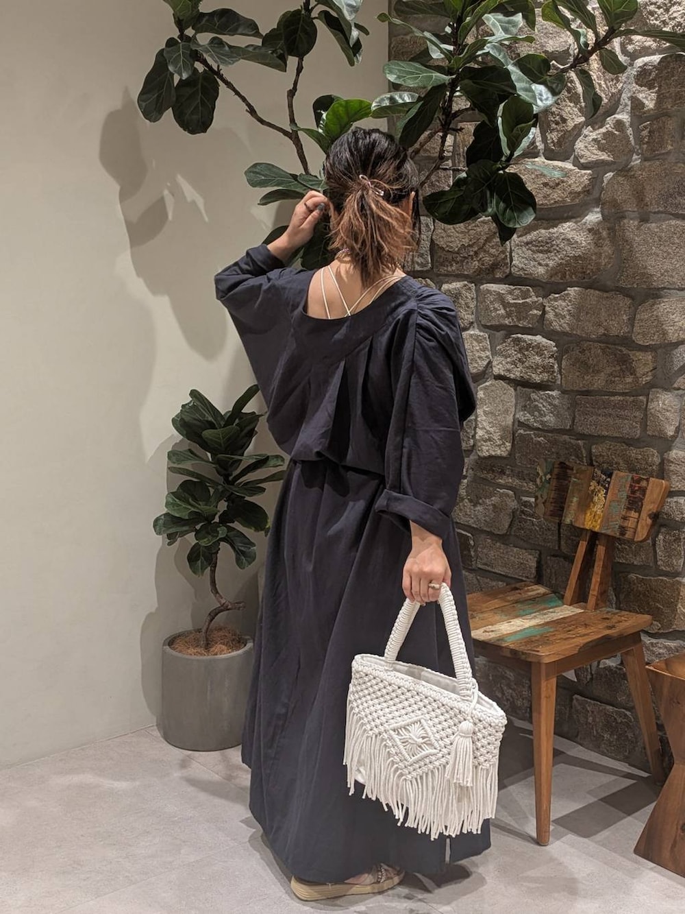 ブルー系のデニムパンツ、シルバー系のサンダル、ベージュ系のトートバッグを着用したレディースの春コーディネートの4枚目の写真