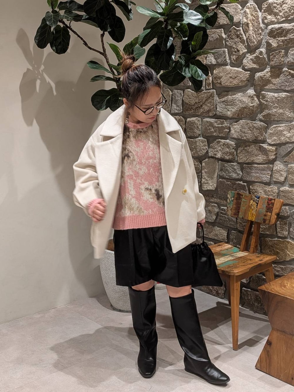 ブラック系のブーツ、ブラック系のハンドバッグを着用したレディースの秋コーディネートの2枚目の写真