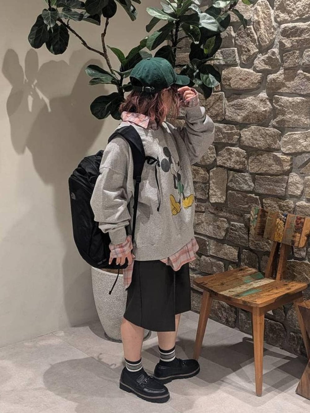 オレンジ系のシャツ/ブラウス、ブラック系のバックパック/リュック、ブラック系のローファーを着用したレディースの冬コーディネートの2枚目の写真