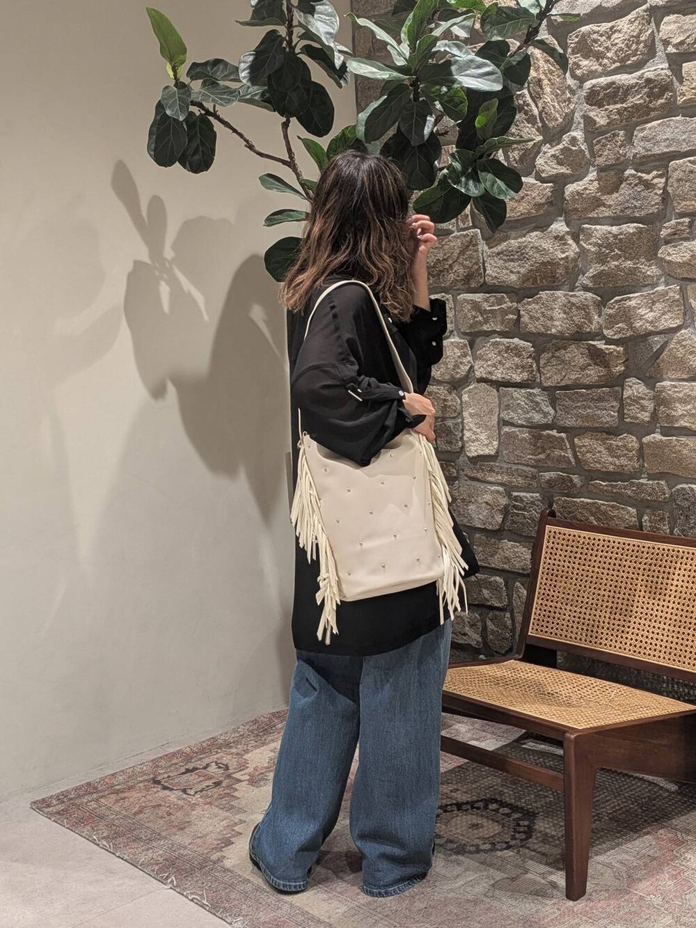 ブラック系のローファー、ベージュ系のショルダーバッグ、ブルー系のデニムパンツを着用したレディースの秋コーディネートの2枚目の写真