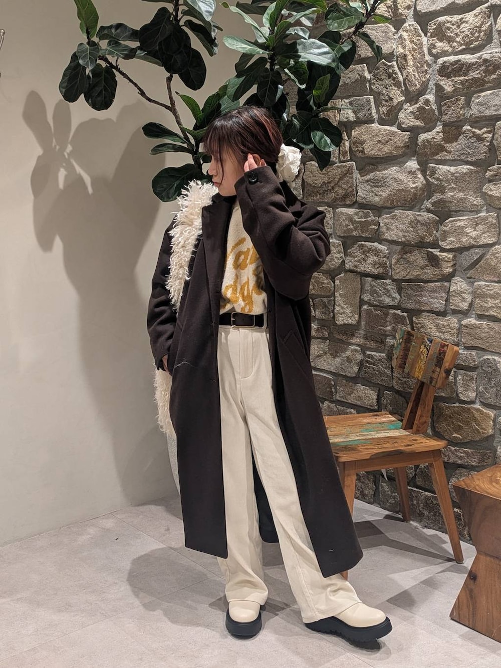 ブラウン系のチェスターコート、ベージュ系のブーツ、ベージュ系のショルダーバッグを着用したレディースの冬コーディネートの2枚目の写真