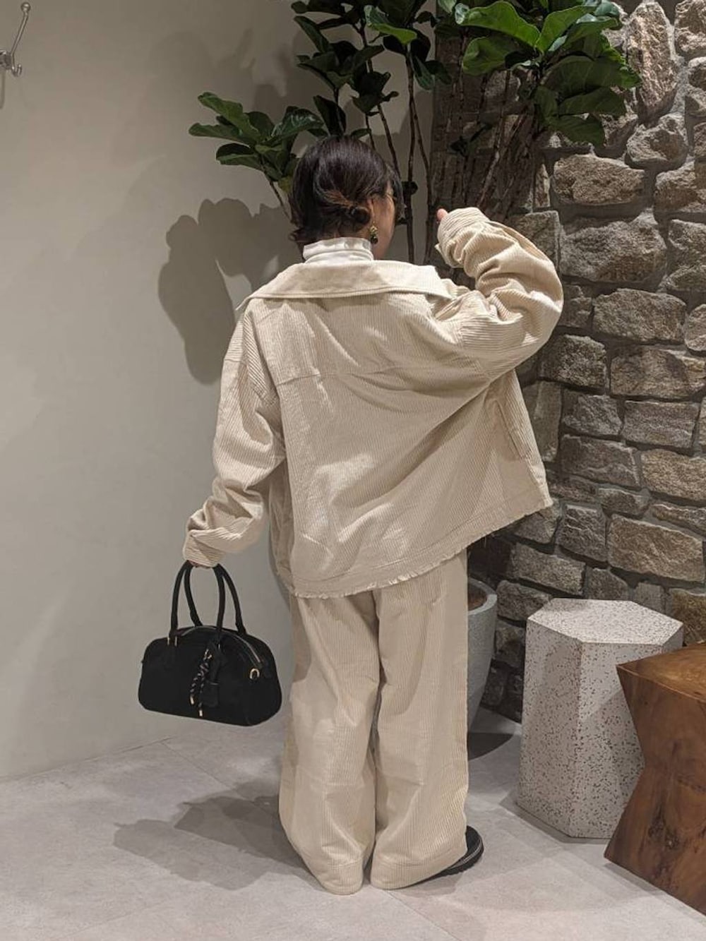ホワイト系のブルゾン、ホワイト系のその他パンツ、ブラック系のハンドバッグを着用したレディースの秋コーディネートの5枚目の写真
