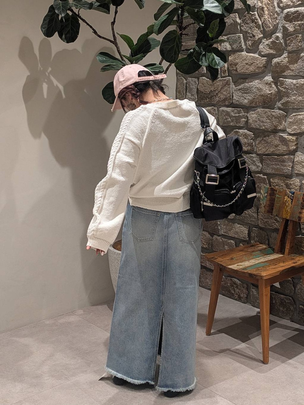 グレー系のスニーカー、ブルー系のデニムスカート、ブラック系のバックパック/リュックを着用したレディースの冬コーディネートの5枚目の写真