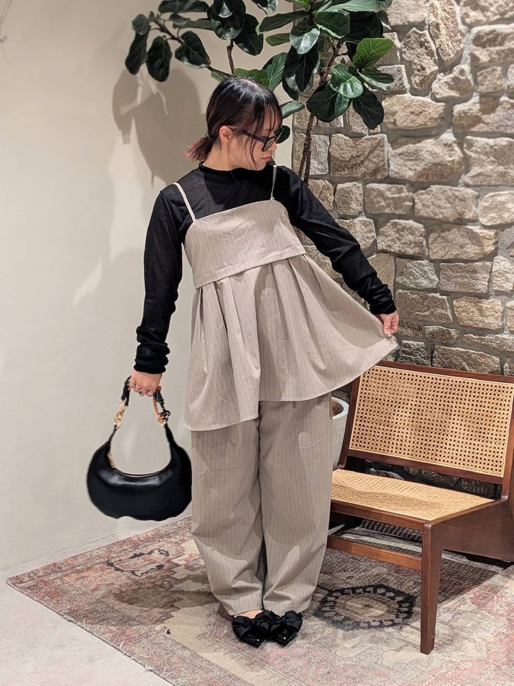 ブラック系のパンプス、ブラック系のTシャツ/カットソー、ベージュ系のその他パンツを着用したレディースの冬コーディネートの2枚目の写真