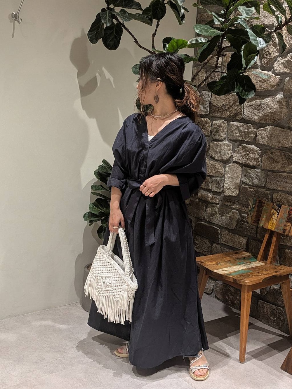 ブルー系のデニムパンツ、シルバー系のサンダル、ベージュ系のトートバッグを着用したレディースの春コーディネートの2枚目の写真