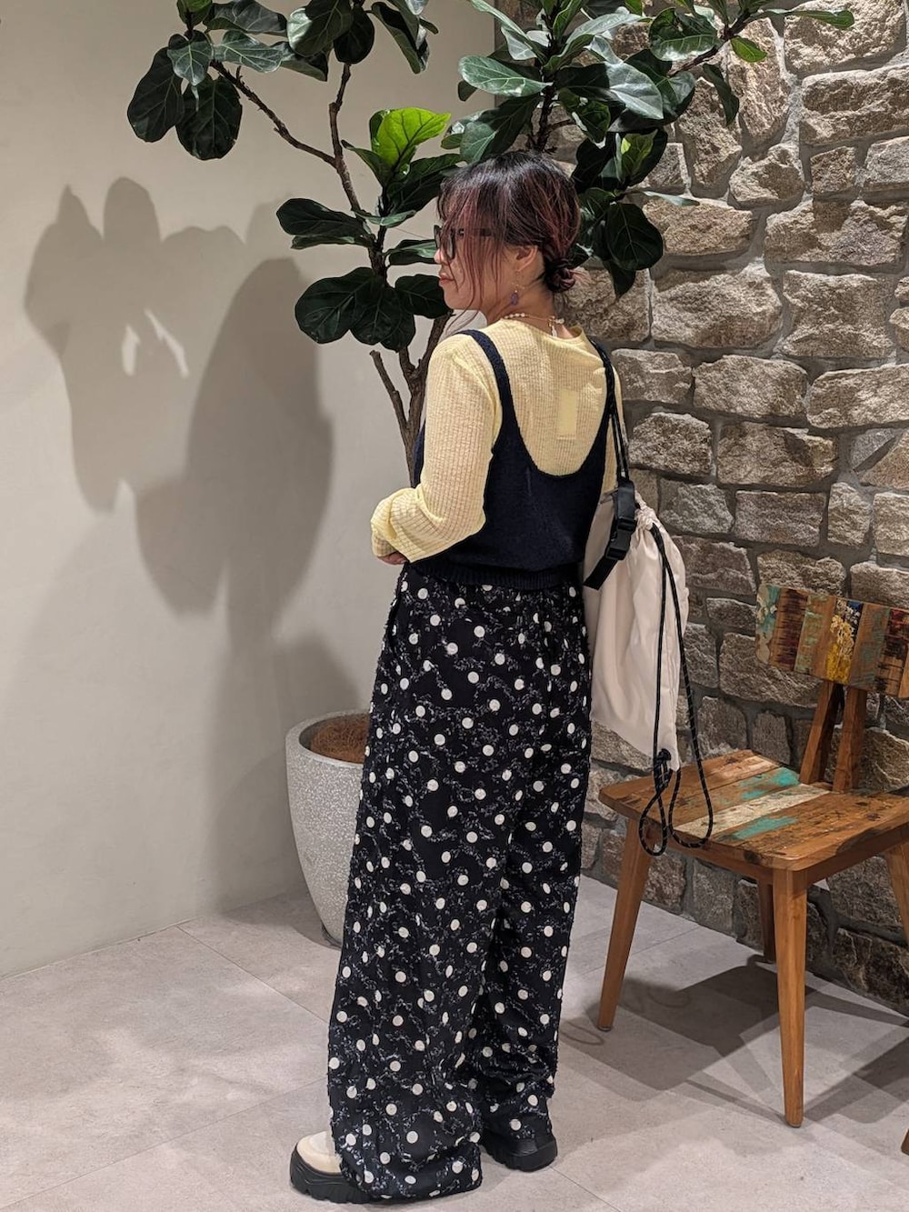 ホワイト系のスニーカー、ホワイト系のバックパック/リュック、ブラック系のその他パンツを着用したレディースの春コーディネートの2枚目の写真