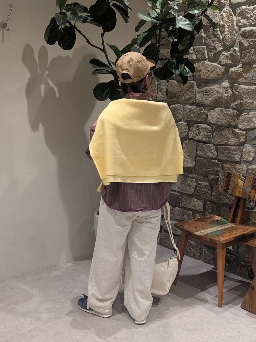 ブルー系のスニーカー、ブラウン系のシャツ/ブラウス、ホワイト系のショルダーバッグを着用したレディースの冬コーディネートの3枚目の写真