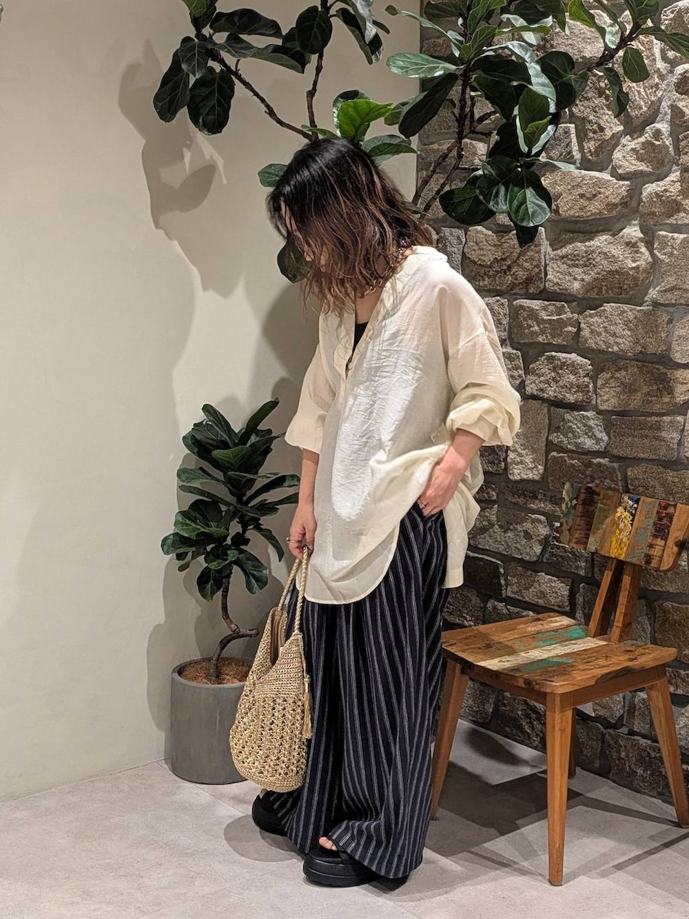 ブルー系のその他パンツ、ブラック系のサンダル、ゴールド系のショルダーバッグを着用したレディースの夏コーディネートの2枚目の写真