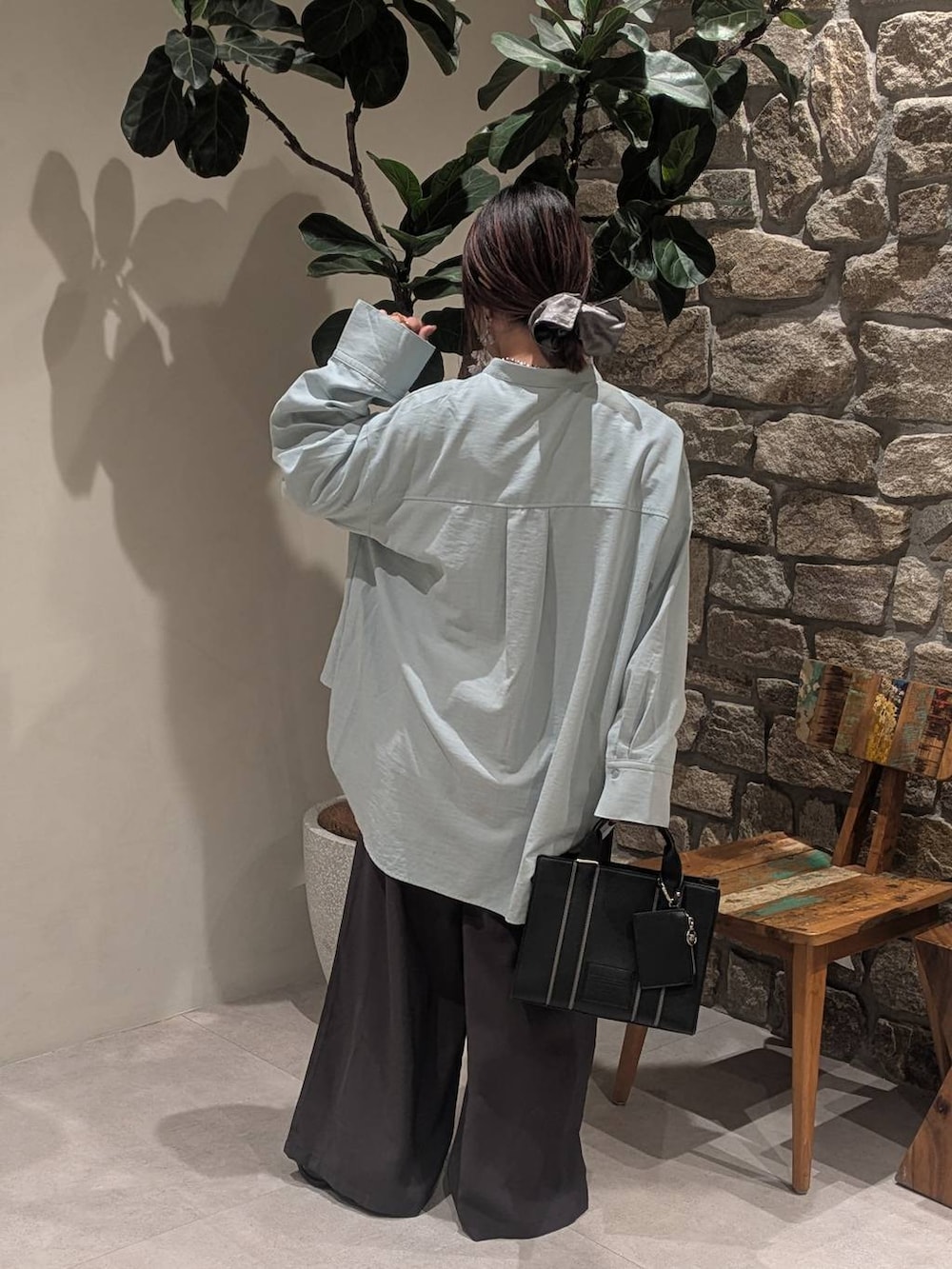 ブラック系のブーツ、ブルー系のシャツ/ブラウス、ブラック系のハンドバッグを着用したレディースの冬コーディネートの4枚目の写真