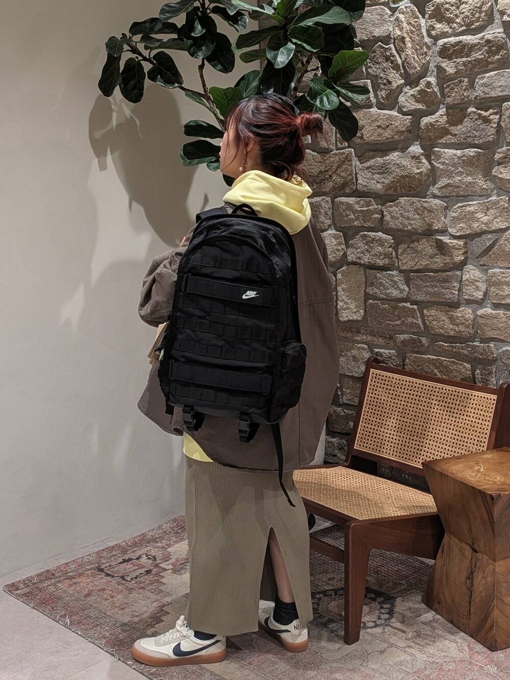 グリーン系のスカート、イエロー系のパーカー、グリーン系のカバーオールを着用したレディースの冬コーディネートの3枚目の写真