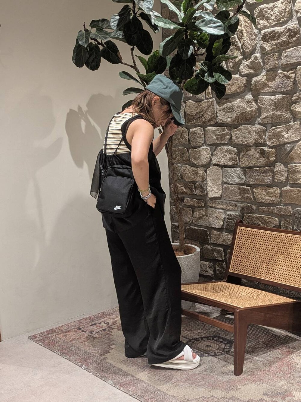 ブラック系のその他トップス、ブラック系のその他パンツ、グリーン系のキャップを着用したレディースの夏コーディネートの2枚目の写真