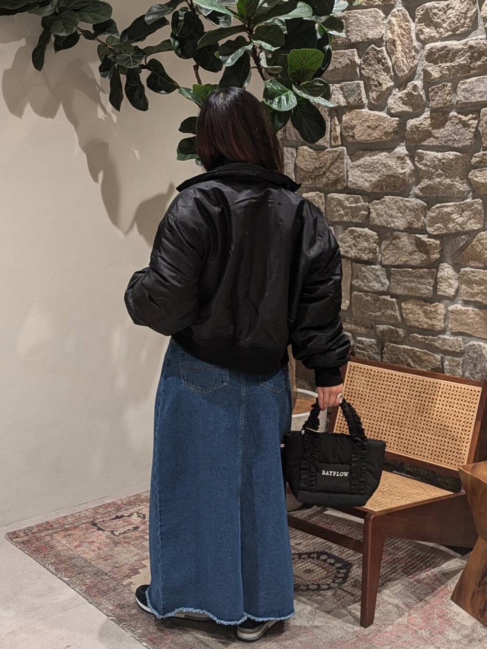 ブラック系のスニーカー、ブラック系のトートバッグ、レッド系のニット/セーターを着用したレディースの冬コーディネートの2枚目の写真