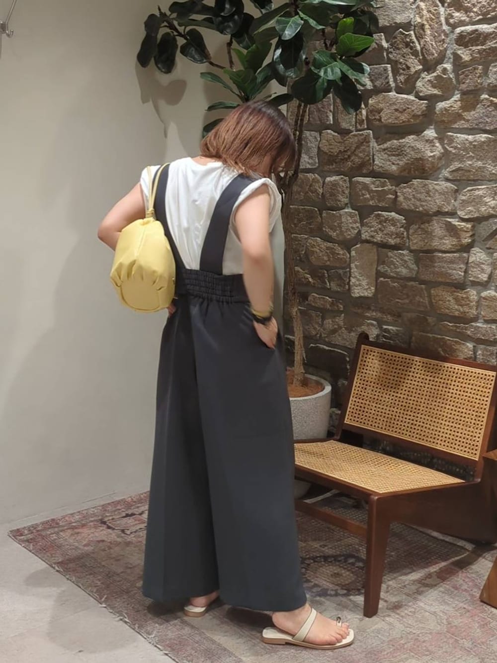 イエロー系のショルダーバッグ、ホワイト系のサンダル、グレー系のサロペット/オーバーオールを着用したレディースの春コーディネートの2枚目の写真