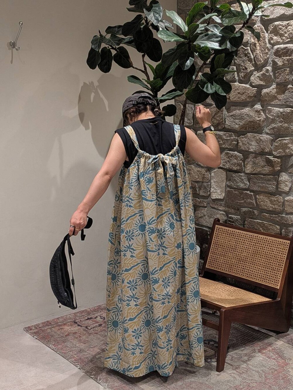 ブラック系のショルダーバッグ、ホワイト系のワンピース、ブラック系のTシャツ/カットソーを着用したレディースの夏コーディネートの2枚目の写真