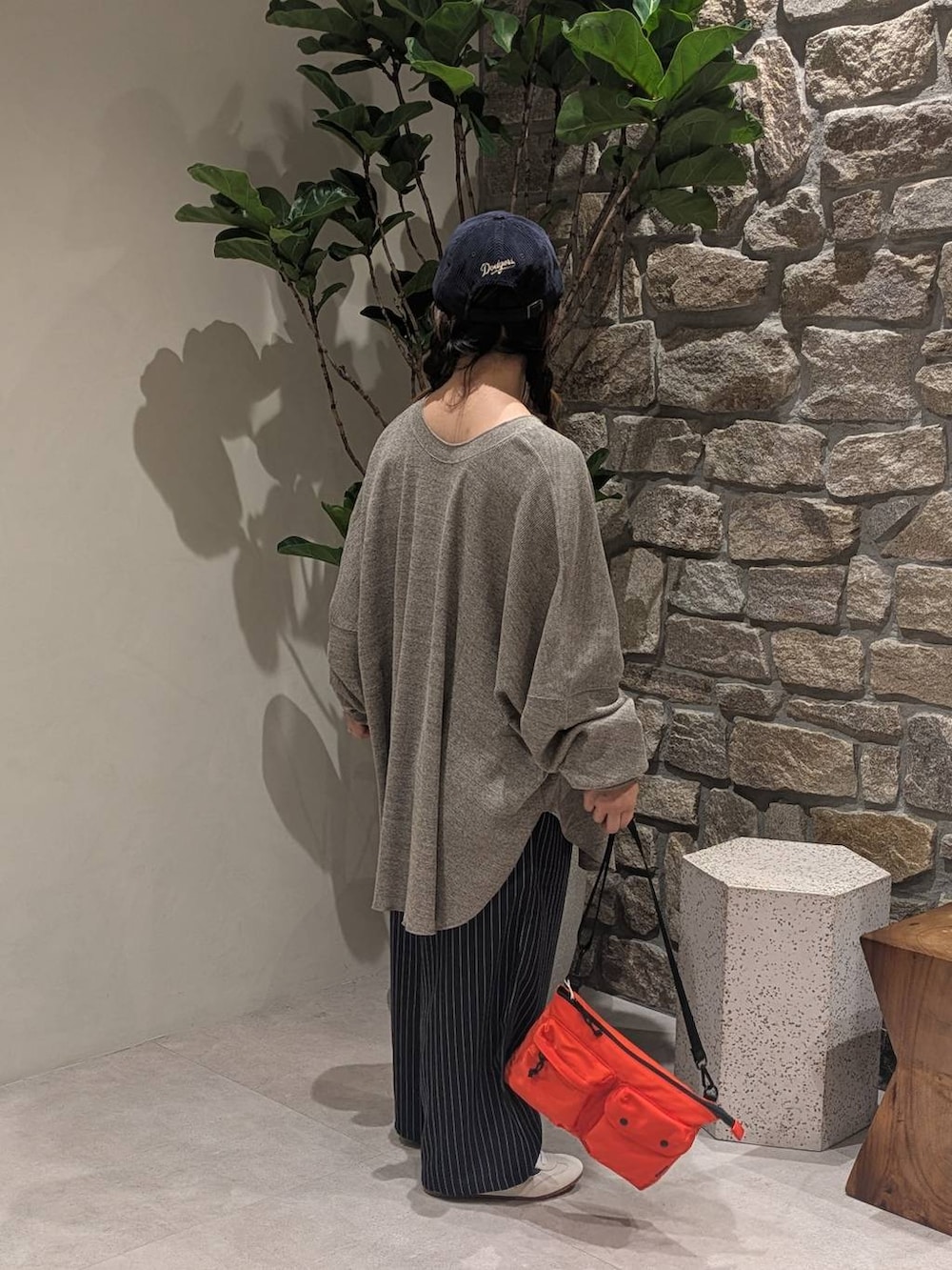 ブルー系のスラックス、ブラウン系のカーディガン/ボレロ、オレンジ系のショルダーバッグを着用したレディースの秋コーディネートの5枚目の写真