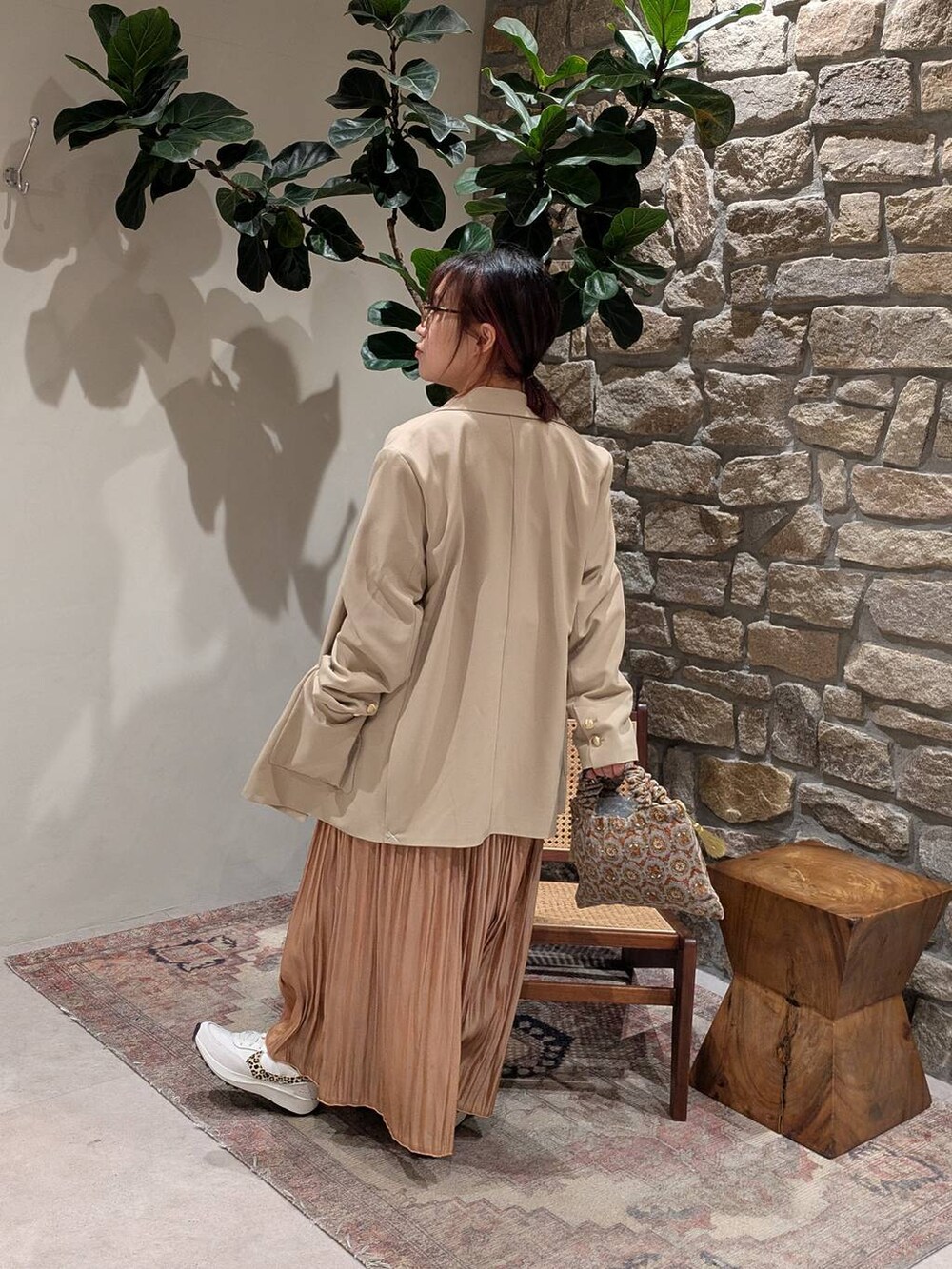 ベージュ系のテーラードジャケット、グレー系のハンドバッグ、ブルー系のニット/セーターを着用したレディースの冬コーディネートの2枚目の写真