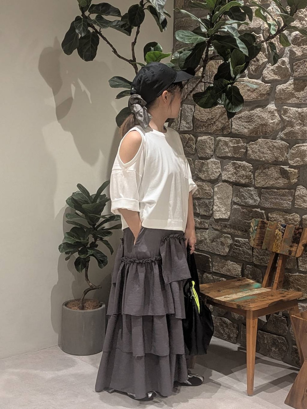 グレー系のワンピース、ブラック系のショルダーバッグ、ブラック系のスニーカーを着用したレディースの夏コーディネートの3枚目の写真