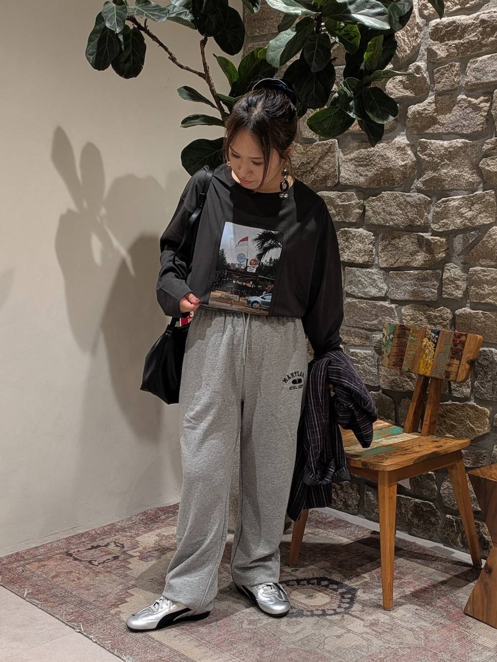 グレー系のスニーカー、グレー系のスウェットパンツ、ブラック系のハンドバッグを着用したレディースの秋コーディネートの3枚目の写真