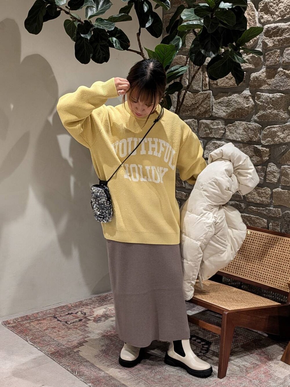 グレー系のショルダーバッグ、ホワイト系のダウンジャケット/コート、ブラウン系のスカートを着用したレディースの秋コーディネートの3枚目の写真